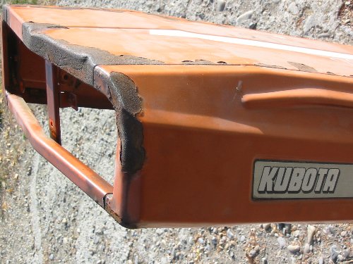 Serious hood rust on the hood of this Kubota is what we are looking to grind down to bare metal with our 60 or 80 grit sandpaper.