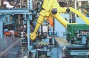 A robot installs pistons on Kubota's automated assembly line.